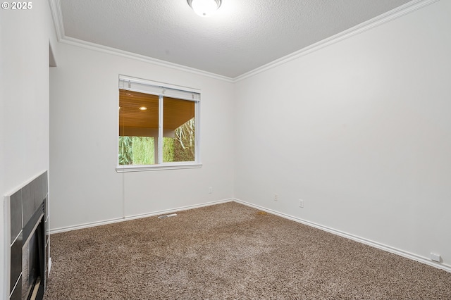 spare room featuring a fireplace, ornamental molding, and carpet