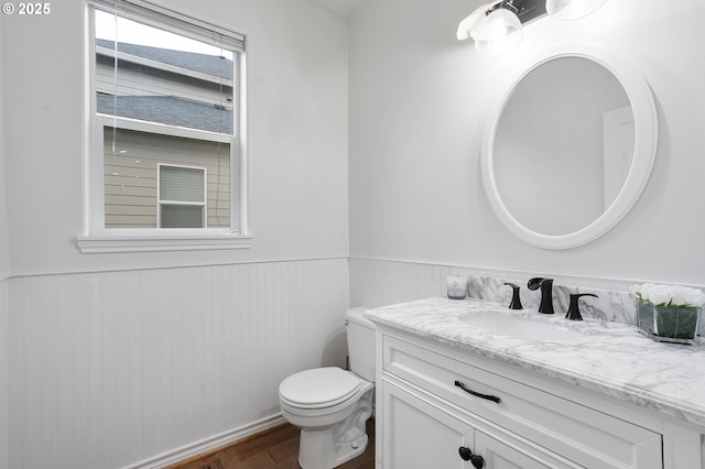 bathroom featuring toilet, hardwood / wood-style floors, and vanity