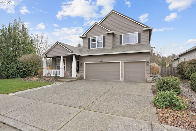 view of front of home featuring a front yard, a garage, and covered porch