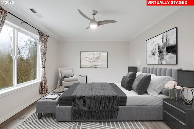 bedroom featuring wood-type flooring, ornamental molding, and ceiling fan