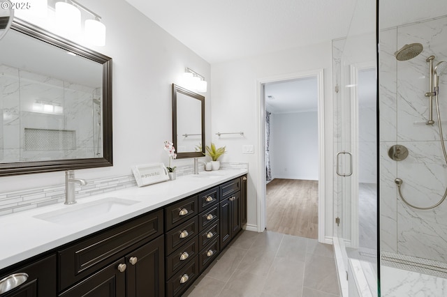 bathroom with tile patterned flooring, a shower with door, decorative backsplash, and vanity