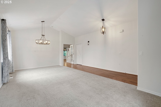 spare room with lofted ceiling, a notable chandelier, and carpet flooring