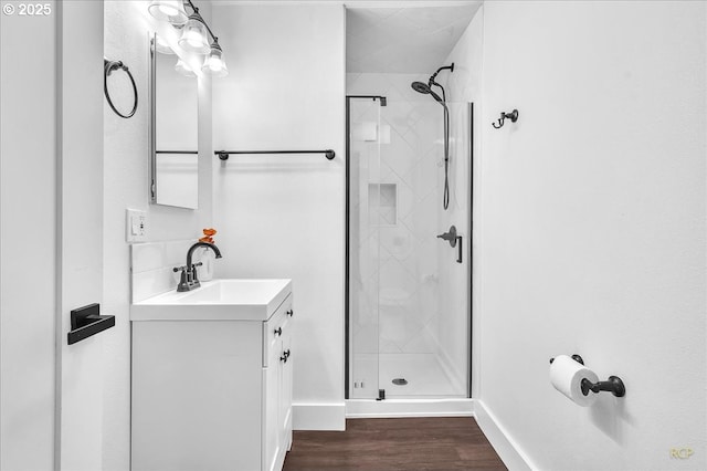 bathroom featuring hardwood / wood-style flooring, walk in shower, and vanity