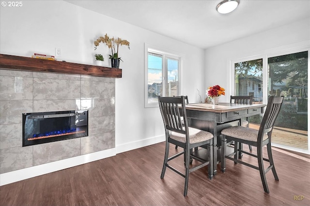 dining room with dark hardwood / wood-style flooring and a fireplace