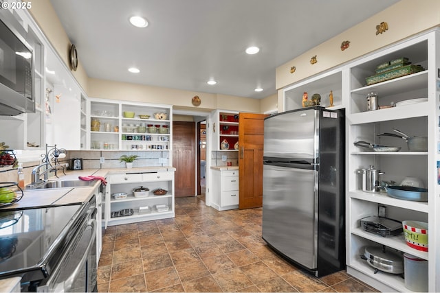 kitchen with open shelves, stainless steel appliances, recessed lighting, light countertops, and a sink