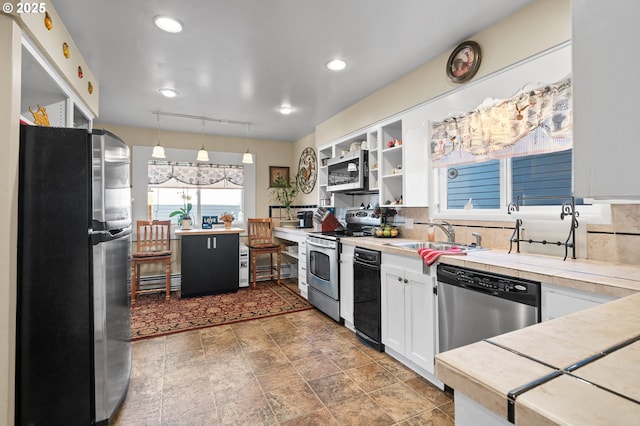 kitchen featuring decorative backsplash, stainless steel appliances, light countertops, white cabinetry, and a sink