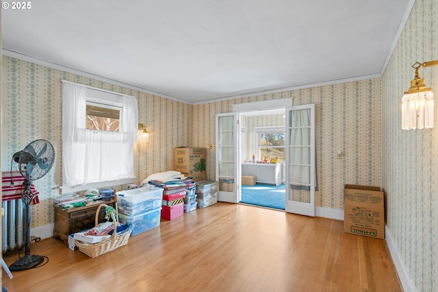 interior space with baseboards, ornamental molding, wood finished floors, and wallpapered walls