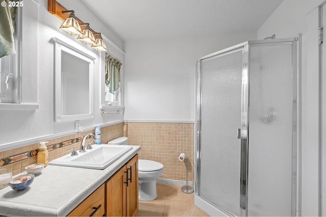 bathroom with a stall shower, vanity, toilet, and tile patterned floors