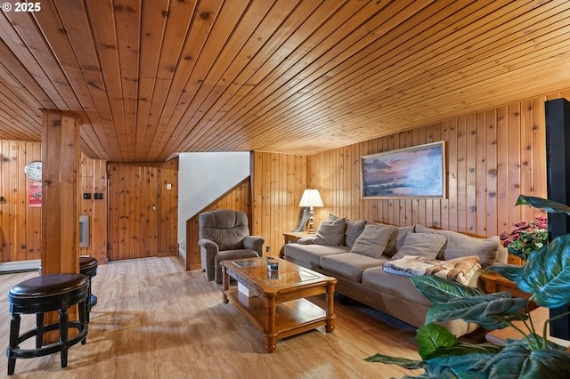 living area with a baseboard heating unit, wood ceiling, wooden walls, and wood finished floors