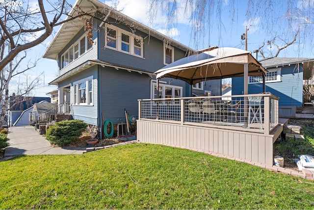 rear view of house with a yard and a gazebo