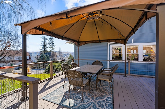 wooden deck with outdoor dining area and a gazebo