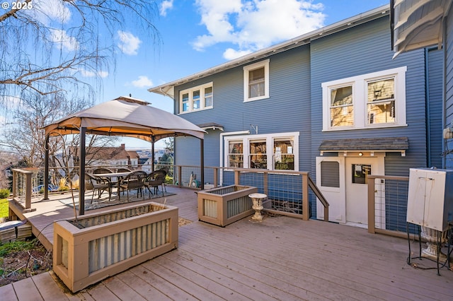 wooden deck with outdoor dining area and a gazebo