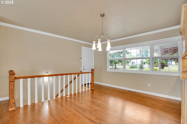 11675 SW Lynn St, Portland, OR 97223 - empty room featuring wood finished floors, a chandelier, ornamental molding, and baseboards