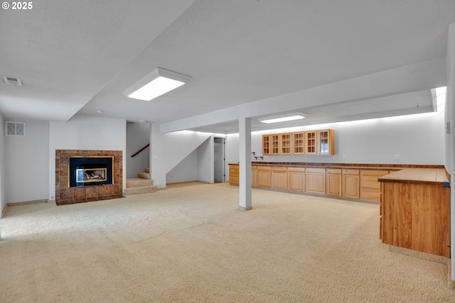 11675 SW Lynn St, Portland, OR 97223 - finished basement with a tile fireplace, light colored carpet, stairs, and bar area