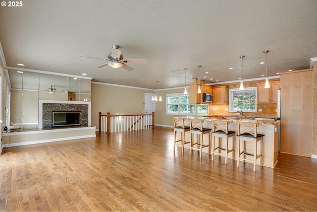 11675 SW Lynn St, Portland, OR 97223 - kitchen with ceiling fan, a breakfast bar, stainless steel microwave, recessed lighting, and light wood finished floors
