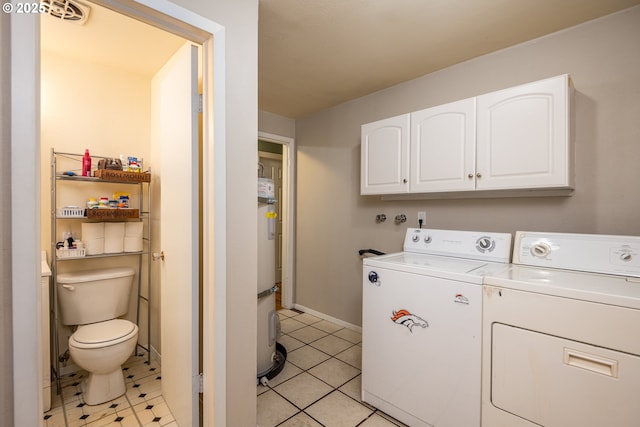 laundry room with cabinet space, baseboards, light tile patterned flooring, and washing machine and clothes dryer