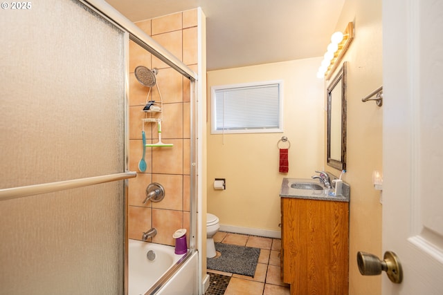 full bath featuring shower / bath combination with glass door, toilet, vanity, baseboards, and tile patterned floors