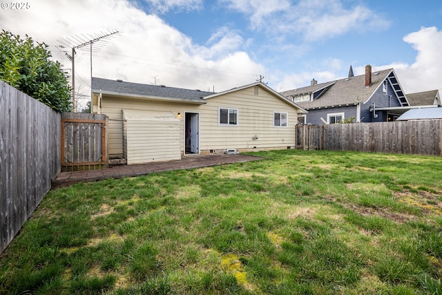 back of house featuring a fenced backyard and a lawn