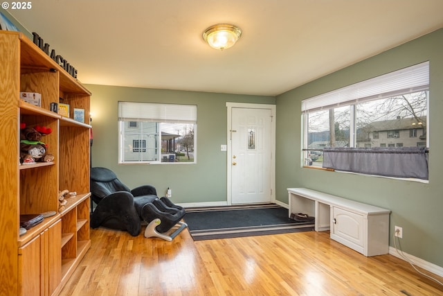 foyer featuring baseboards and wood finished floors