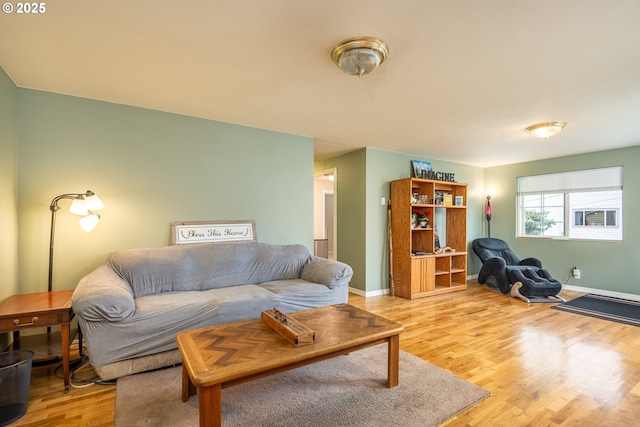 living area featuring light wood-style floors and baseboards