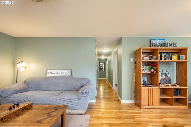 living area featuring light wood-style floors and baseboards