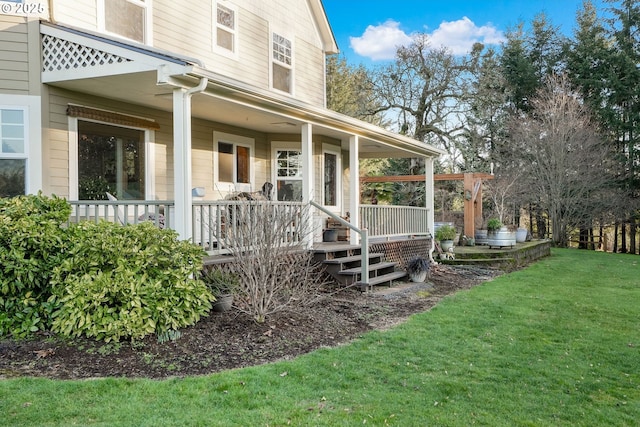 doorway to property with a porch and a lawn