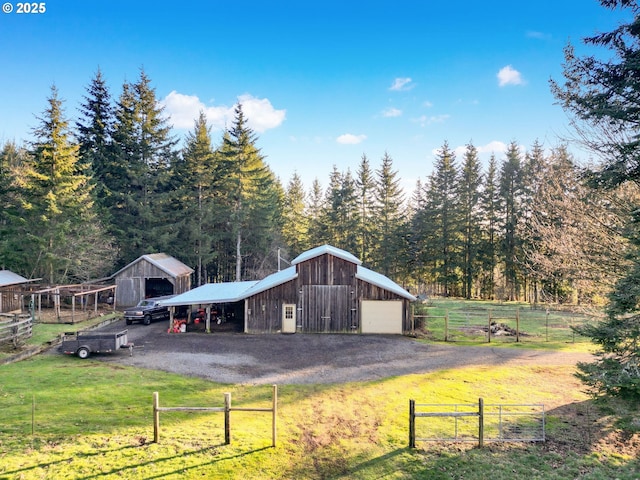 exterior space featuring a yard, a garage, and a rural view