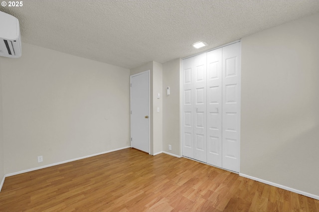 unfurnished bedroom with light wood-style floors, baseboards, a closet, and a textured ceiling