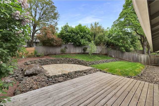 wooden terrace with a lawn, a fenced backyard, and a patio area