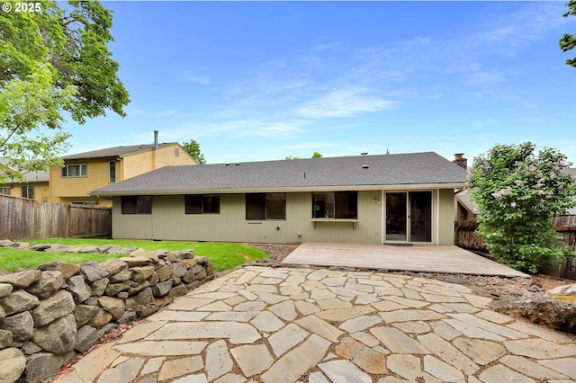 back of property with a wooden deck, a fenced backyard, a patio area, and a chimney