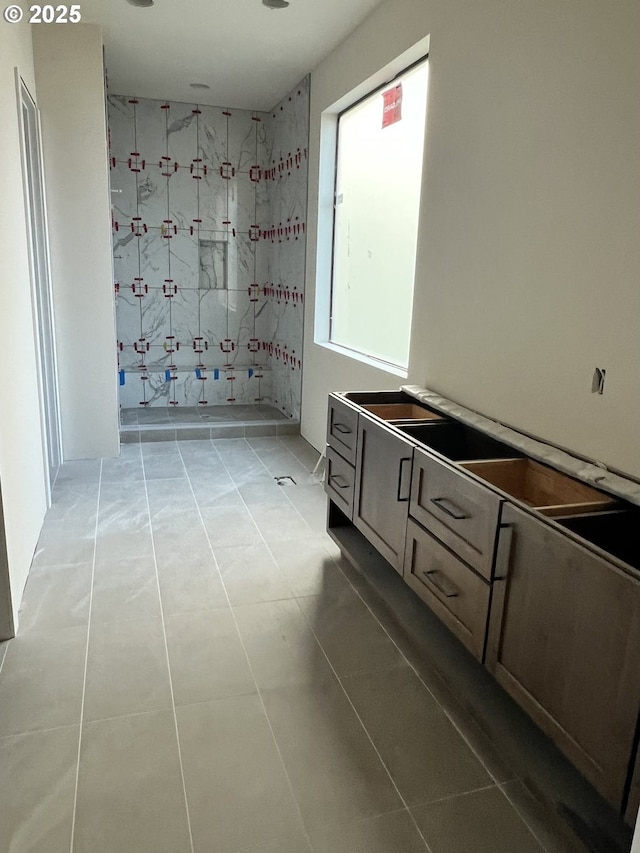 bathroom with a shower, tile patterned floors, and vanity