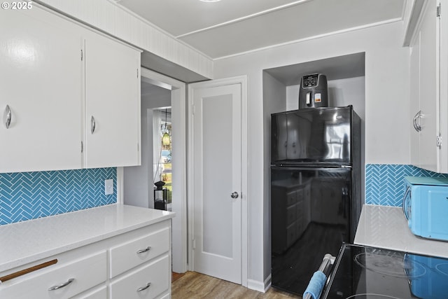 1538 Grove St, Eugene, OR 97404 - kitchen featuring black appliances, tasteful backsplash, white cabinets, light countertops, and light wood-type flooring