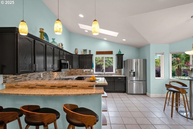3275 Redwood Loop, Florence, OR 97439 - kitchen with stainless steel appliances, lofted ceiling, tasteful backsplash, a sink, and a skylight