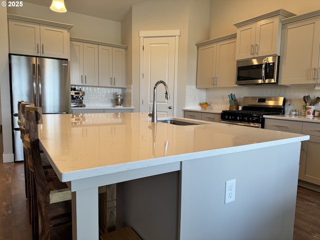 987 Farmington Dr, Junction City, OR 97448 - kitchen featuring appliances with stainless steel finishes, a sink, a center island with sink, tasteful backsplash, and a kitchen breakfast bar