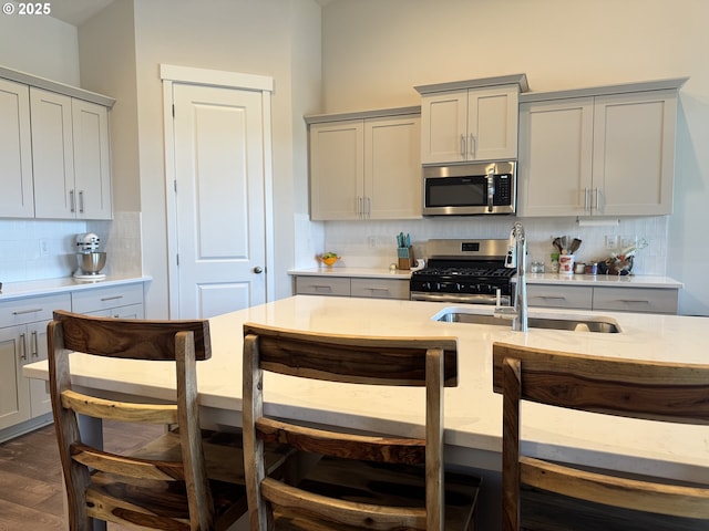 987 Farmington Dr, Junction City, OR 97448 - kitchen featuring stainless steel appliances, a sink, backsplash, gray cabinetry, and dark wood-type flooring