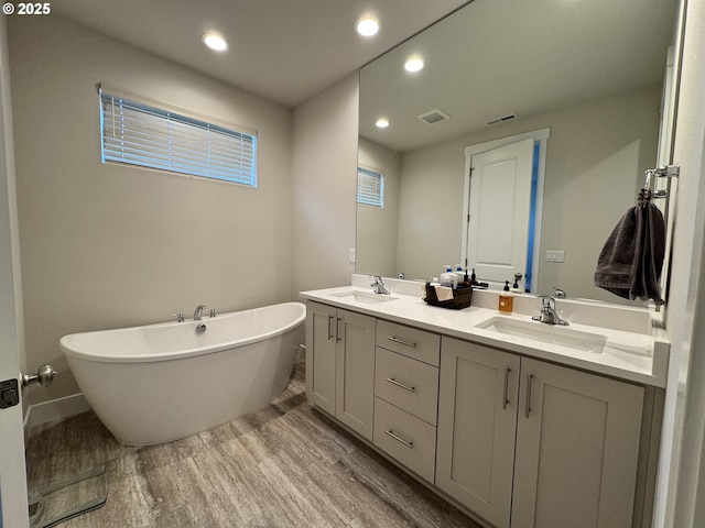 987 Farmington Dr, Junction City, OR 97448 - full bathroom featuring wood finished floors, a freestanding tub, double vanity, and recessed lighting