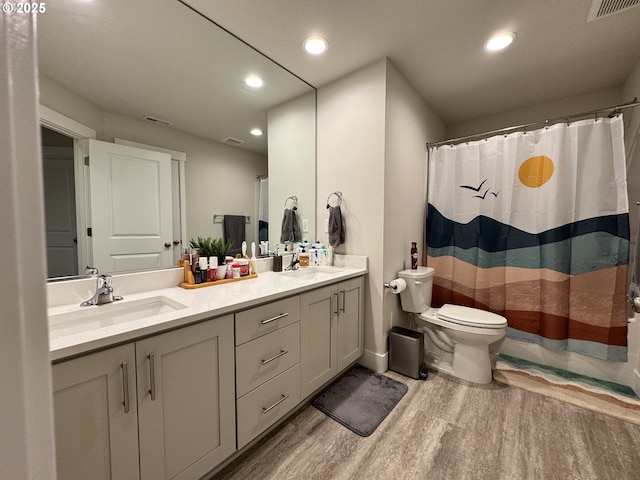 987 Farmington Dr, Junction City, OR 97448 - bathroom featuring wood finished floors, double vanity, toilet, recessed lighting, and curtained shower