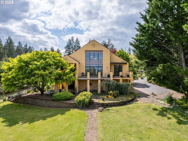 88369 Timberline Dr, Veneta, OR 97487 - back of property featuring a lawn, stucco siding, and a balcony