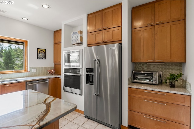 88369 Timberline Dr, Veneta, OR 97487 - kitchen featuring brown cabinetry, tasteful backsplash, a toaster, and appliances with stainless steel finishes