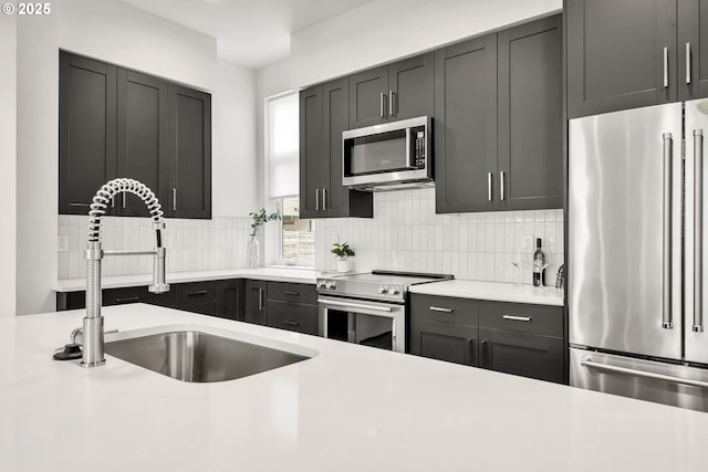 kitchen with backsplash, sink, and appliances with stainless steel finishes