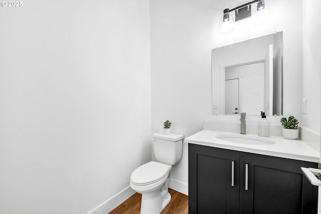 bathroom with hardwood / wood-style floors, vanity, and toilet