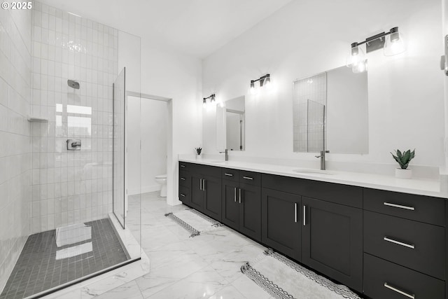 bathroom featuring tiled shower, vanity, and toilet