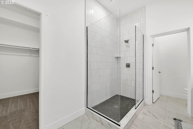 bathroom with toilet and a tile shower