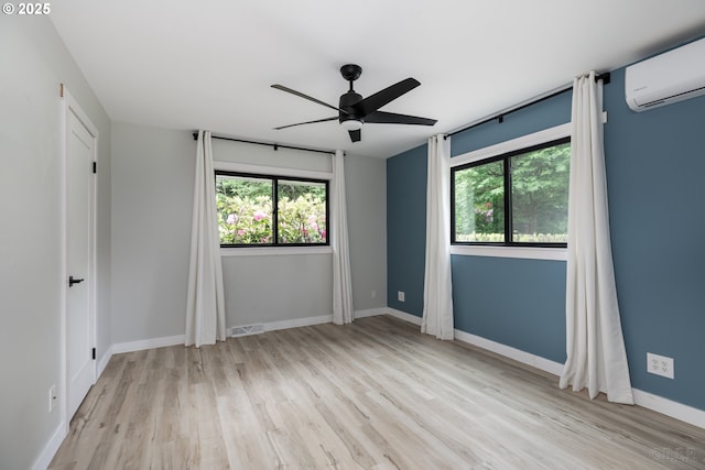 27539 Kingsley Rd, Scappoose, OR 97056 - spare room featuring an AC wall unit, plenty of natural light, ceiling fan, and wood finished floors