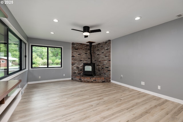 27539 Kingsley Rd, Scappoose, OR 97056 - unfurnished living room with a wood stove, recessed lighting, a ceiling fan, light wood-style floors, and baseboards