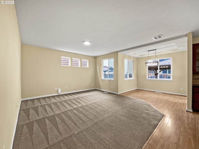 interior space with baseboards, visible vents, and wood finished floors