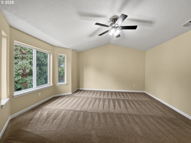 unfurnished room featuring lofted ceiling, a textured ceiling, carpet, and baseboards