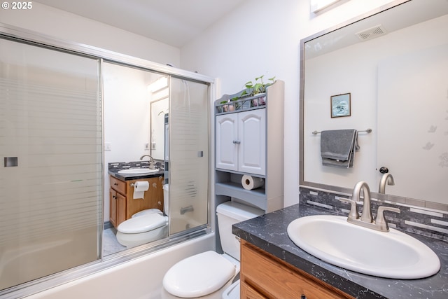 full bathroom featuring vanity, toilet, and bath / shower combo with glass door