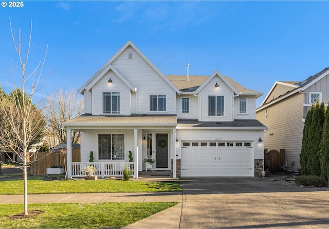 view of front of home featuring a garage, a front yard, and covered porch