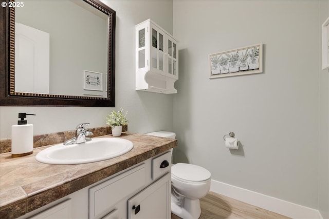 bathroom with hardwood / wood-style floors, toilet, and vanity